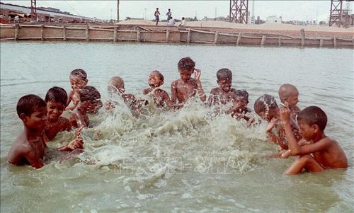 Trẻ em tắm mát tránh nắng nóng ở Dhaka, Bangladesh. AFP/TTXVN