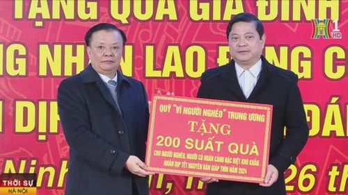 Ủy viên Bộ Chính trị, Bí thư Thành ủy Đinh Tiến Dũng trao tượng trưng các suất quà của Quỹ Vì người nghèo Trung ương