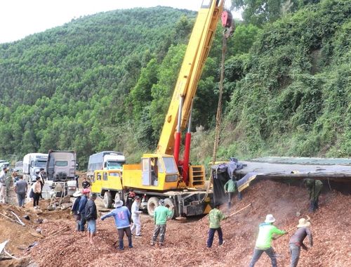Xe container chở vụn gỗ, lật nghiêng chiếm ½ mặt đường, gây tắc nghẽn giao thông. Ảnh: Ngọc Minh