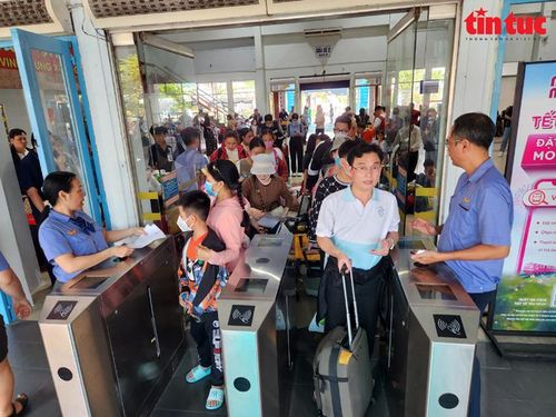Hành khách đi qua cổng soát vé để vào ga.