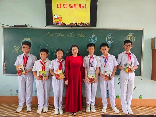 Học sinh lớp 6/3, Trường THCS Nguyễn Du (phường Ia Kring, TP. Pleiku) vui vẻ nhận sách và phong bao lì xì năm mới từ cô giáo chủ nhiệm. Ảnh: Mộc Trà