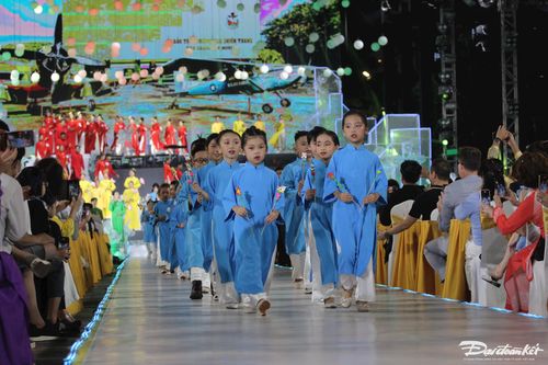 Các em bé thích thú với chiếc áo dài trình diễn tại lễ khai mạc.