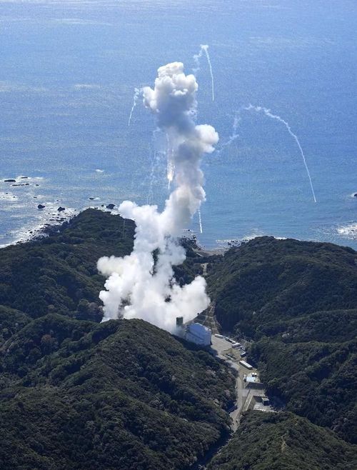 Khói bốc lên và các mảnh vỡ tên lửa rơi xuống. Ảnh: Kyodo News