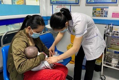 Tiêm vắc xin phòng bệnh chủ động cho trẻ.