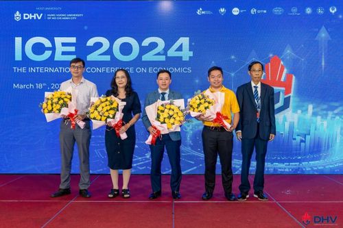 TS. Trần Văn Hưng - Phó Hiệu trưởng nhà trường tặng hoa cho GS. Lê Quốc Hội và các đơn vị đồng tổ chức 