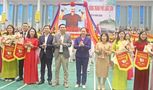 Đồng chí Đoàn Thị Loan, Bí thư Thành ủy (thứ 4 từ phải sang) và Lãnh đạo UBND thành phố cùng các đại biểu trao cờ lưu niệm cho các đoàn vận động viên