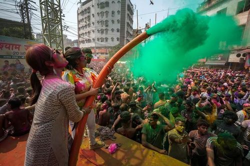 Phụ nữ phun bột màu lên người tham gia lễ hội Holi ở Guwahati, đông bắc Ấn Độ. (Ảnh: Anupam Nath/AP).