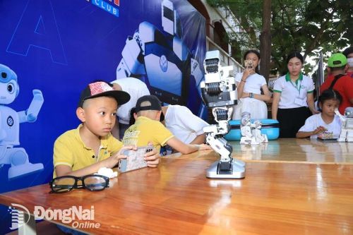 Học sinh thích thú khi có thể điều khiển được robot cử động thông qua điện thoại thông minh. Ảnh: Công Nghĩa
