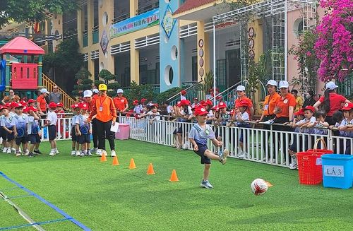 Các bé tham gia trò chơi vượt chướng ngại vật đá bóng vào khung thành. Ảnh: Mộc Trà