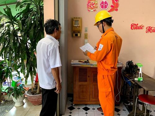 Công nhân điện lực đến từng hộ dân tuyên truyền tiết kiệm điện. Ảnh: Hải Yến/BNEWS/TTXVN