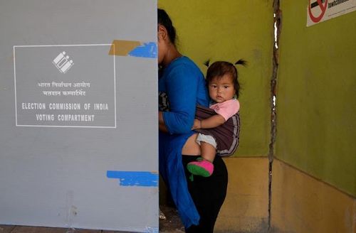 Một người phụ nữ bế con gái đi bỏ phiếu ở làng biên giới Zokhawthar, huyện Champhai, bang Mizoram, phía Đông Bắc Ấn Độ, ngày 19/4/2024. (Ảnh: Reuters)