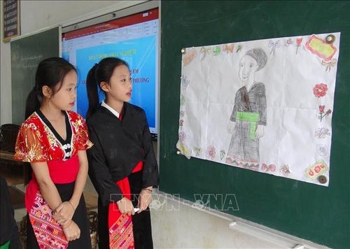 Nhóm học sinh lớp 6A, Trường Phổ thông Dân tộc bán trú và Trung học cơ sở Nga My, huyện Tương Dương, Nghệ An giới thiệu về bộ trang phục truyền thống của phụ nữ Ơ Đu. Ảnh: Xuân Tiến/TTXVN