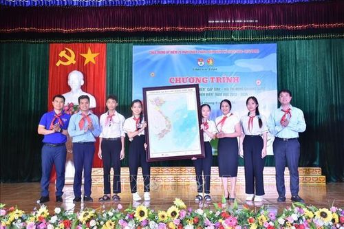 Ban tổ chức trao tặng 20 Bản đồ Việt Nam cho Trường Tiểu học và Trung học cơ sở Phan Đình Giót. Ảnh: TTXVN phát