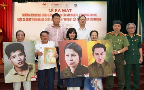 Bảo tàng Phụ nữ Việt Nam cùng đại diện các gia đình liệt sỹ, người có công trong kháng chiến tiếp nhận các bức ảnh được phục dựng từ nhóm nghệ sỹ trẻ "Trái tim người lính".