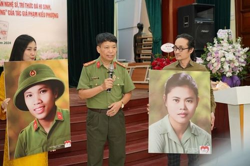 Nhà văn Đặng Vương Hưng và nhóm họa sĩ trẻ "Trái tim người lính" bên những bức ảnh được phục dựng màu. 