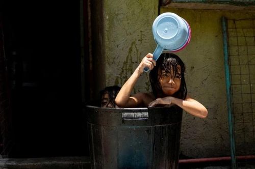 Trẻ em tắm trong ngày nắng nóng ở Manila (Philippines) ngày 25/4Reuters