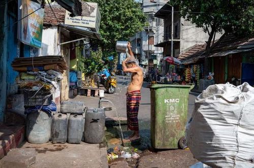 Một người đàn ông tắm trên đường phố trong đợt nắng nóng ở Tây Bengal, Ấn Độ. Ảnh: Shutterstock .