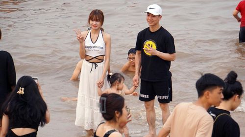 Du khách chụp ảnh lưu niệm ở bãi tắm.