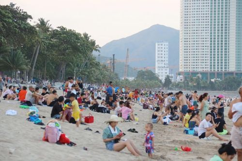 Bãi biển Nha Trang bắt đầu đông đúc khách từ chiều 27/4 khi nhiệt độ dịu mát dần. Ảnh: Tường Vi.