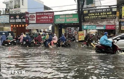  Nước ngập gần nửa bánh xe trên đường Lê Văn Thọ (quận Gò Vấp). (Ảnh: Hồng Giang/TTXVN) 