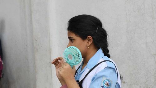 Chiếc quạt cầm tay là thiết bị làm mát quen thuộc của học sinh ở khu vực châu Á trong mùa nóng. Ảnh: Palash Khan.