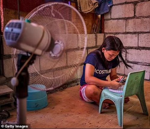 Cô gái ngồi trong nhà tránh nóng ở Philippines. Ảnh: Getty. 