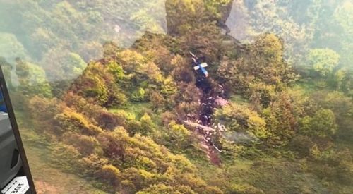 Lực lượng cứu nạn phát hiện xác trực thăng cháy rụi trên một sườn núi - Ảnh: AFP