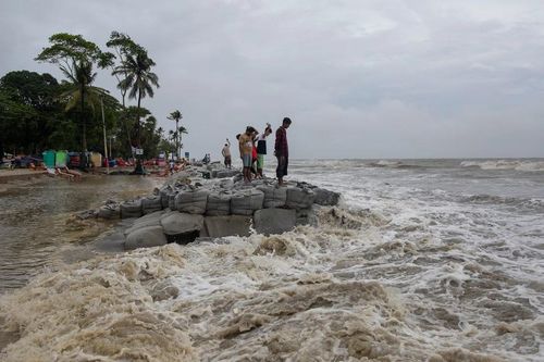 Người dân địa phương đứng gần biển khi bão Remal đổ bộ vào Bangladesh. Nguồn: Getty Images.