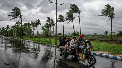Người dân di chuyển khi những đám mây mưa che phủ bầu trời do ảnh hưởng của bão nhiệt đới Remal, ở Kolkata, Ấn Độ. Nguồn: Getty Images.