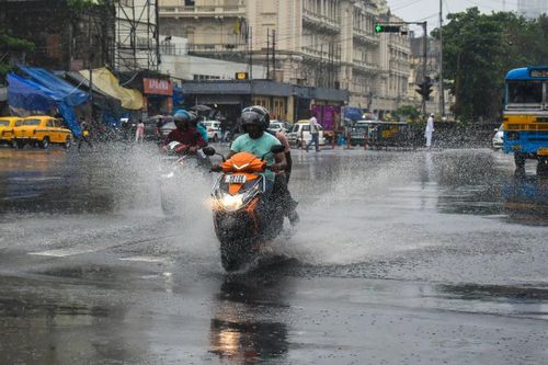Người dân di chuyển trên đường phố trước khi bão Remal đổ bộ vào Kolkata, Ấn Độ. Nguồn: Getty Images.