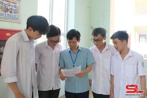 Thầy và trò nhà trường trao đổi bài ngoài giờ lên lớp.