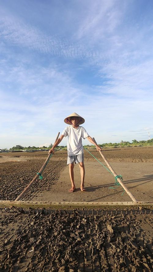 Để làm ra hạt muối phải qua rất nhiều công đoạn như: xới xáo đất, phơi đất, đưa đất vào chạt lọc (khu vực lọc lấy nước mặn), lọc nước, phơi nước, thu muối. Mỗi ngày, tôi ra đồng từ 5 giờ sáng, việc đầu tiên là làm đất để phơi cho kịp nắng. Đất sau khi phơi khô sẽ được cho vào bể lọc để lấy nước biển.