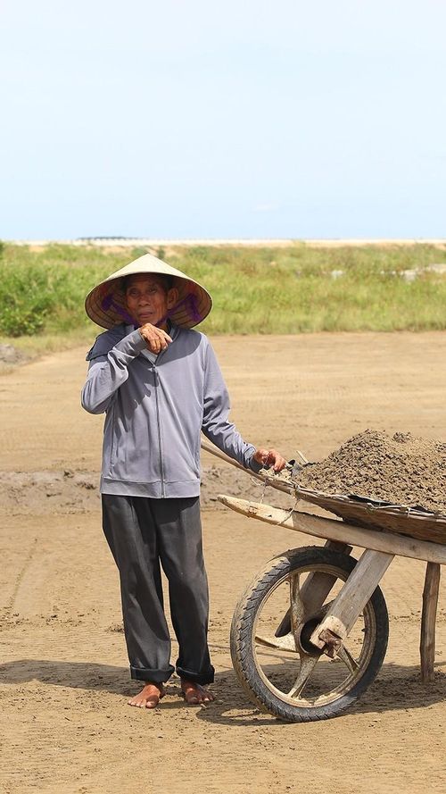 Cái nắng, gió thổi rát ràn rạt, hầm hập vị mặn chát phả thẳng vào mặt khiến công việc của những diêm dân như chúng tôi thêm phần vất vả, cực nhọc hơn. Có lẽ, không có nghề nào dãi dầu nắng nóng như nghề làm muối.