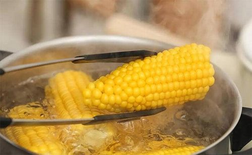 Sau khi tắt bếp, nên ngâm ngô thêm trong nước nóng. (Ảnh Sohu)