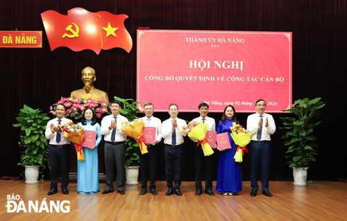 Bí thư Thành ủy Nguyễn Văn Quảng (thứ 4, phải sang) trao quyết định cho các cán bộ; Phó Bí thư Thường trực Thành ủy Nguyễn Đình Vĩnh (bên trái); Chủ tịch UBND thành phố Lê Trung Chinh (bên phải) và Chủ tịch HĐND thành phố Ngô Xuân Thắng (thứ 3, trái sang) tặng hoa chúc mừng các cán bộ được phân công, luân chuyển, điều động. Ảnh: NGỌC PHÚ