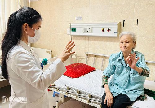 Bác sĩ Bệnh viện Đa khoa Đồng Nai hướng dẫn một cụ già tập vận động. Ảnh:H.Dung