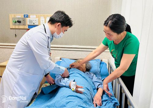 Một người cao tuổi được bác sĩ và người nhà thăm khám, chăm sóc tại Bệnh viện Đồng Nai - 2. Ảnh: HẠNH DUNG