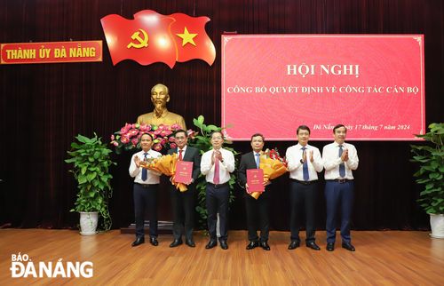 Bí thư Thành ủy Nguyễn Văn Quảng (thứ 3, trái sang) trao quyết định cho các cán bộ và Thường trực Thành ủy, HĐND thành phố tặng hoa chúc mừng. Ảnh: NGỌC PHÚ