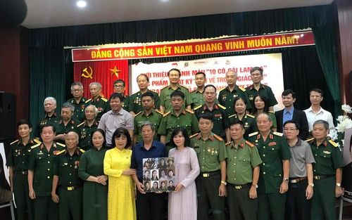 Đại diện Bảo tàng Phụ nữ Việt Nam tiếp nhận di ảnh phục dựng 10 nữ liệt sĩ dân quân Lam Hạ.
