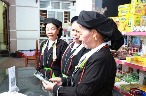 Người dân Làng văn hóa kiểu mẫu Đồng Bùa, xã Tam Quan sử dụng hình thức thanh toán không dùng tiền mặt khi mua hàng hóa. Ảnh: Thế Hùng