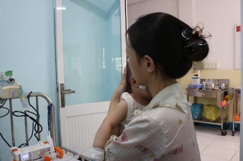  Bé Huy ngủ thiếp đi trong vòng tay mẹ. Ảnh: Kỳ Duyên. 