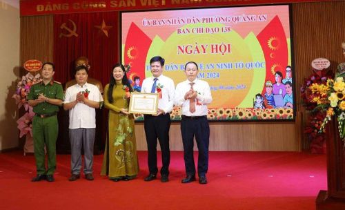 Đồng chí Nguyễn Lan Hương - Chủ tịch Ủy ban MTTQ Việt Nam thành phố tặng Bằng khen của UBND thành phố cho Phường Quảng An. Ảnh: Hoàng Hương