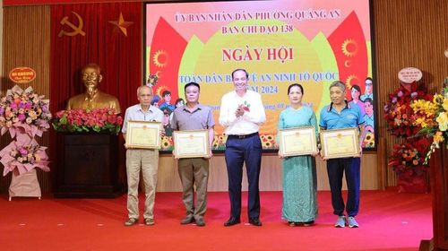 Đồng chí Nguyễn Đình Khuyến - Chủ tịch UBND quận tặng giấy khen cho các đơn vị, cá nhân có thành tích xuất sắc trong phong trào toàn dân bảo vệ tổ quốc tại phường Quảng An. Ảnh: Hoàng Hương
