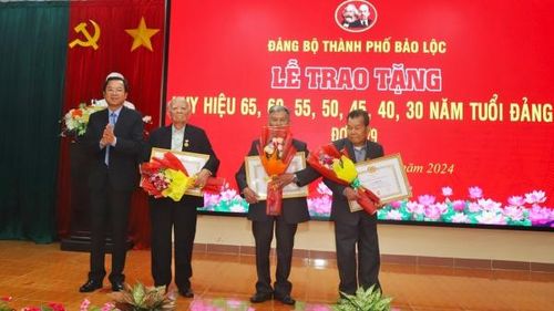 Đồng chí Tôn Thiện Đồng - Ủy viên Ban Thường vụ Tỉnh ủy, Bí thư Thành ủy Bảo Lộc trao Huy hiệu 65 tuổi Đảng cho các đảng viên