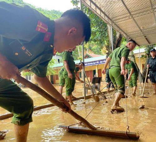 Lực lượng Công an huyện Tương Dương hỗ trợ giáo viên dọn dẹp. Ảnh Tương Dương.