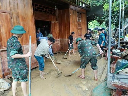 Lực lượng quân đội hỗ trợ dọn dẹp nhà cửa tại gia đình bị ảnh hưởng bởi trận mưa lũ. Ảnh Tương Dương.
