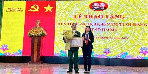 Đồng chí Trần Thị Chúc Quỳnh - Bí thư Huyện ủy Lạc Dương trao Huy hiệu Đảng cho đảng viên 45 năm tuổi Đảng