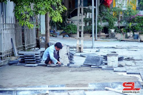 Công nhân lát đá vỉa hè tại khu vực tiểu khu 6, thị trấn Phù Yên.