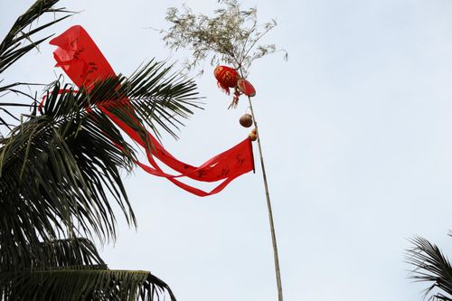 Cây Nêu cao vút với dải vải đỏ bay trong gió.