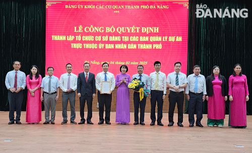 Lãnh đạo Đảng ủy Khối các cơ quan thành phố tặng hoa và trao quyết định cho Ban chấp hành Đảng bộ Ban Quản lý dự án đầu tư xây dựng các công trình giao thông và nông nghiệp Đà Nẵng. Ảnh: THÀNH LÂN